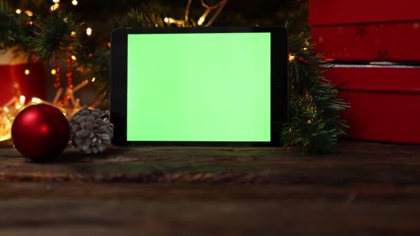 Fond de Noël boîte cadeau rouge gadget tablette écran vert lumières de table en bois — Video