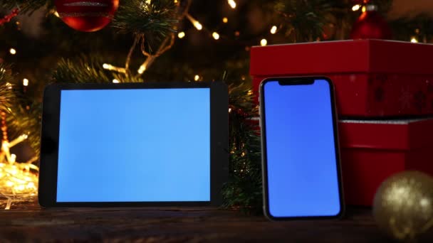 Vánoce pozadí červená dárková krabička tablet smartphone modrá obrazovka jedle strom světla — Stock video