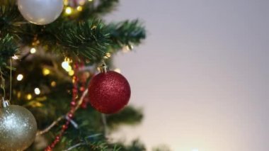 Süslü Noel ağacı yanıp sönen ışıklar ve beyaz arka planda kırmızı beyaz toplar.