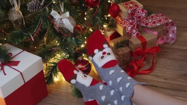 Dwie kobiety nogi z bożonarodzeniowych skarpetek na nogi pod ozdobione jodły prezent — Wideo stockowe