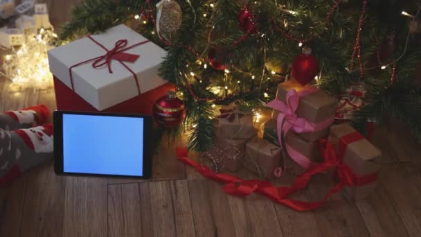 Navidad rojo artesanía cajas de regalo y tableta pantalla mockup azul bajo el abeto — Vídeo de stock