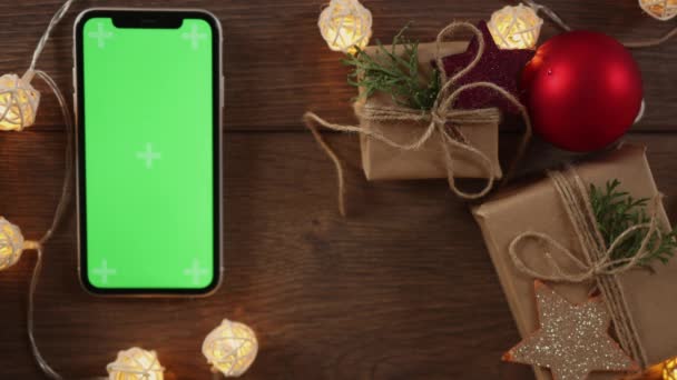 Opakowanie DIY prezent świąteczny smartfon zielony ekran na drewnianym stole — Wideo stockowe