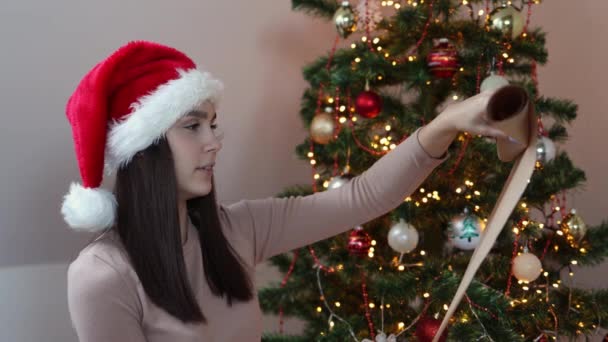 Брюнетка белая белая женщина в красной шляпе читает письмо с пожеланиями Рождества — стоковое видео