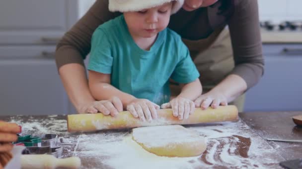 Noel Baba şapkalı 3 yaşındaki çocuk mutfakta Noel kurabiyesi yapıyor. — Stok video