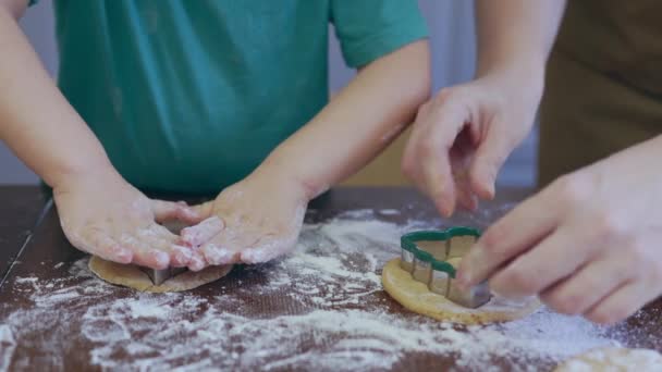 Malé dětské ručičky a matka vyřezávají těstoviny z těsta — Stock video