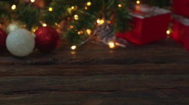 Kırmızı beyaz süs topları yanıp sönen çelenk hediye kutusu tahtanın üzerindeki köknar ağacı.