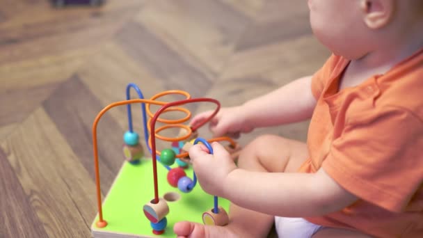 Baby infant developing fine motor skills playing bead maze roller coaster toy — Stock Video