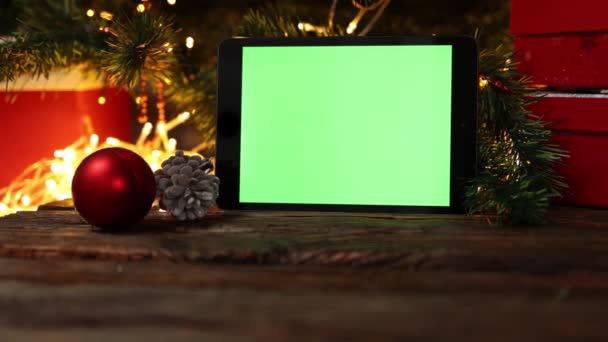 Χριστουγεννιάτικο φόντο κόκκινο κουτί δώρου tablet gadget πράσινο οθόνη ξύλινα φώτα τραπέζι — Αρχείο Βίντεο