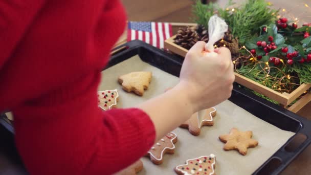 Hand red decorating gingerbread biscuits white icing sugar glaze winter holidays — Stock Video