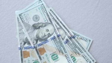 Gri arka plana dökülen 100 dolarlık banknotlar