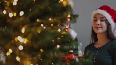 Noel Baba şapkalı güzel bir bayan Noel ağacına benziyor.