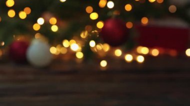 Bulanık noel ağacı yanıp sönen altın ışıklar kırmızı hediye kutusu koyuyor. 