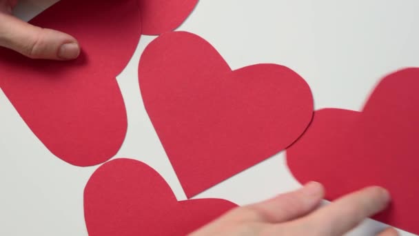 Manos moviendo forma de corazón rojo de fondo blanco de papel. San Valentín amor — Vídeo de stock