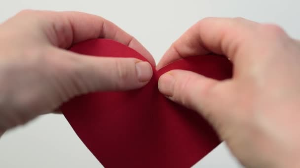 Handen scheuren rood papier hart op twee halve close-up uitzicht — Stockvideo