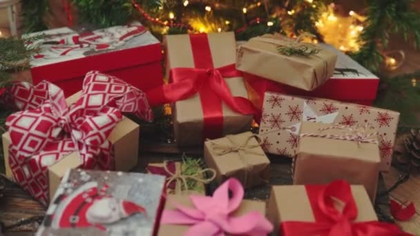 Много рождественских подарков бумажные коробки красные луки ленты елки огни — стоковое видео