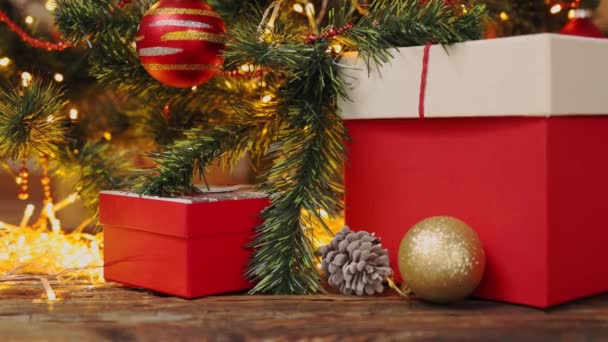Χριστουγεννιάτικο φόντο διακοσμημένο έλατο αναβοσβήνει φώτα κόκκινα κουτιά δώρων στολίδια — Αρχείο Βίντεο