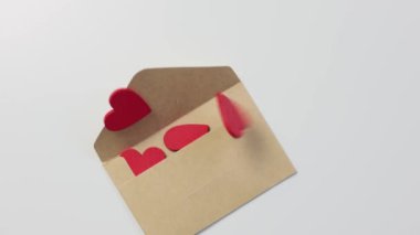 Kağıttan bir zarf düştü ve içindeki kırmızı tahta kalpler dışarı çıktı.