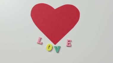 Beyaz ve renkli harfler üzerine kırmızı kağıt kalp altında aşk, kavram ilişkileri 