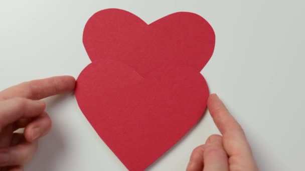 Dos corazones de papel rojo que cubren letras de madera palabra amor, apertura de la mano eliminación — Vídeos de Stock