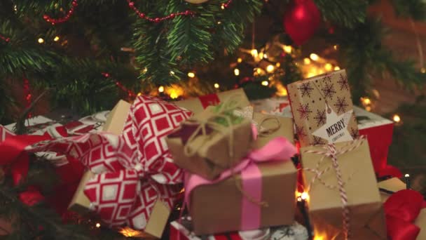 Sok karácsonyi ajándékok kézműves papír dobozok piros íjak szalag fenyő fények — Stock videók