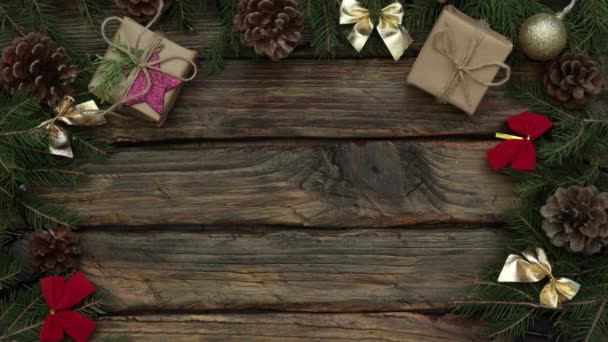 Dekoracje świąteczne na drewnianym tle, pudełka z prezentami rzemieślniczymi, światła, choinka — Wideo stockowe