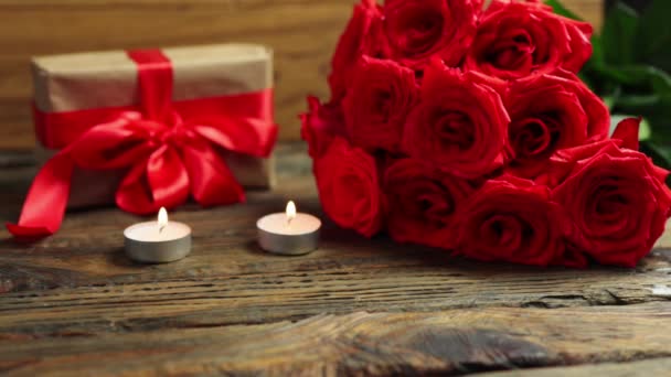 Любі подарунки купа червоних троянд, що палять свічки на дерев'яному столі Валентинів день — стокове відео