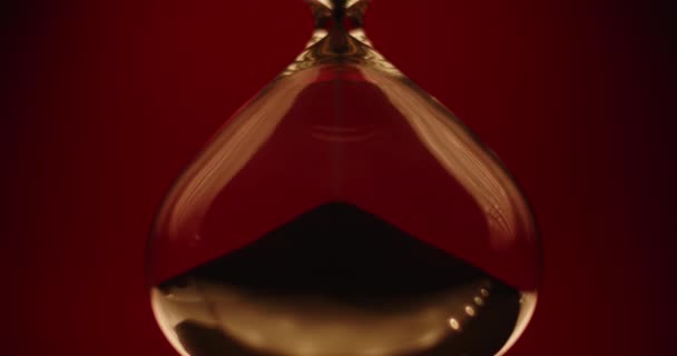 Relógio de areia bonita em um fundo vermelho — Vídeo de Stock