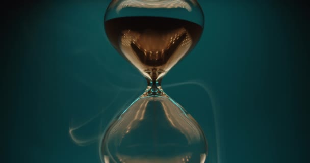 Глянцевий піщаний годинник на сльозогінному фоні — стокове відео