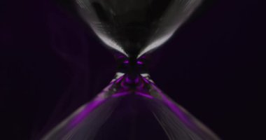 Değişen menekşe arkaplanı üzerindeki kum saati