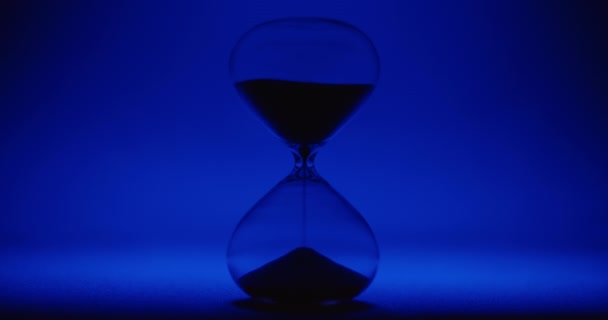 Reloj de arena sobre fondo azul — Vídeo de stock