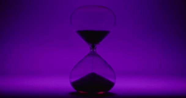 Vidrio de hora sobre fondo de color violeta — Vídeos de Stock