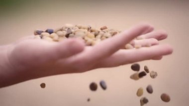 Kadın parmaklarından düşen çakıl taşları