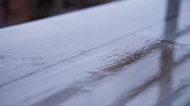 Terasa yağmur damlaları yağıyor.