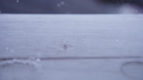 Druppels regen op houten terrasvloer — Stockvideo