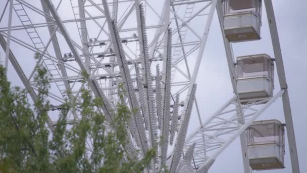 Rueda de la fortuna girando lentamente en un parque — Vídeos de Stock