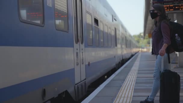 Femme masquée à côté d'un train qui passe — Video