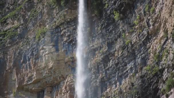 Высокий водопад брызгает со скалы — стоковое видео