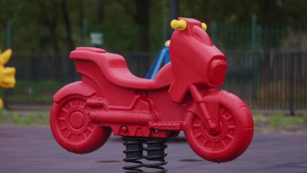 Rood nat kinderspeelgoed op speelplaats — Stockvideo