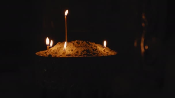 Płonące świece stoją na piasku — Wideo stockowe