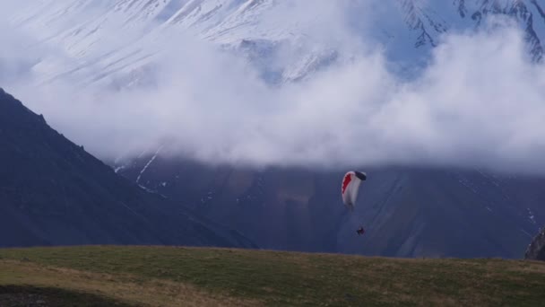 Paracaídas volando entre altas montañas — Vídeo de stock