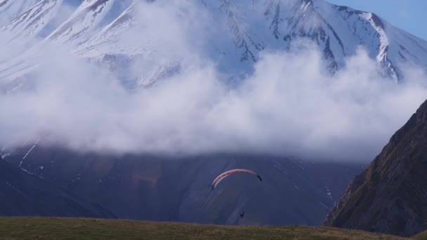 Paragliden in de besneeuwde bergen — Stockvideo