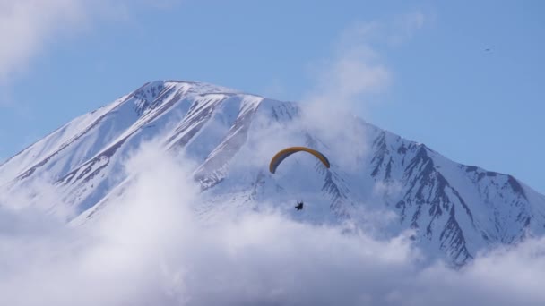 Gleitschirm fliegt gegen Berggipfel — Stockvideo