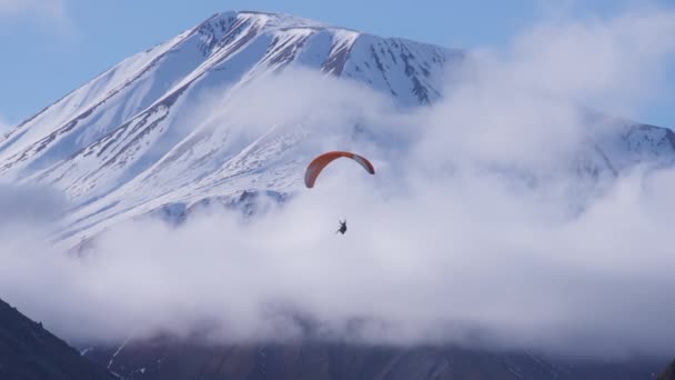 Le parachutiste vole près des sommets montagneux — Video