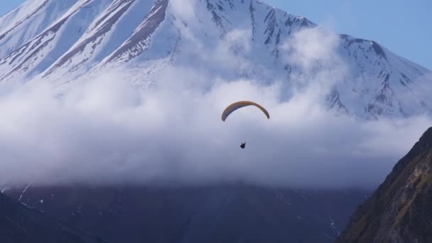 Paracaídas deslizándose junto a la montaña nevada — Vídeo de stock