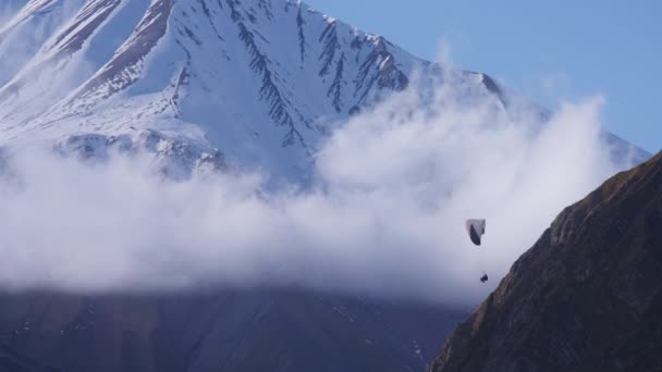 Parapente entre montañas y nubes — Vídeo de stock