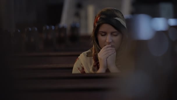 Femme en foulard priant à l'église — Video