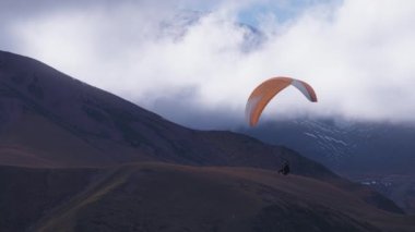 Gökyüzünde renkli paraşüt süzülüyor