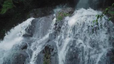 Büyük kayaların üzerine şelale sıçrıyor.