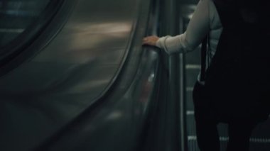 Yürüyen merdivenden inen kadın.