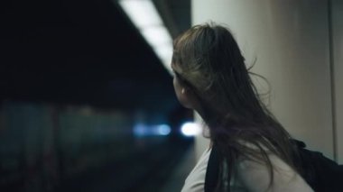 Metroda treni bekleyen bir kadın var.